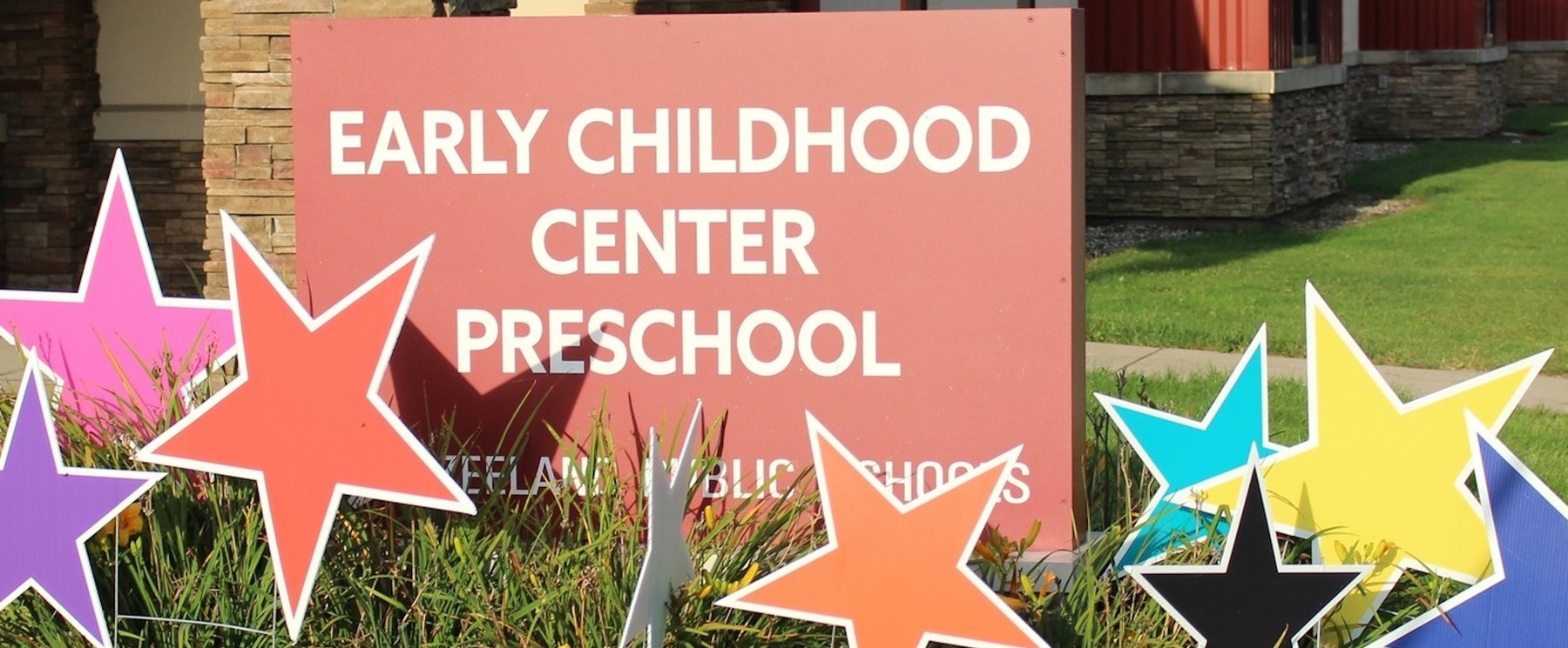 Early Childhood Center Preschool Sign for Zeeland Public Schools outside of the building with stars around it