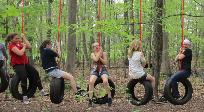 Students hanging on tire swings